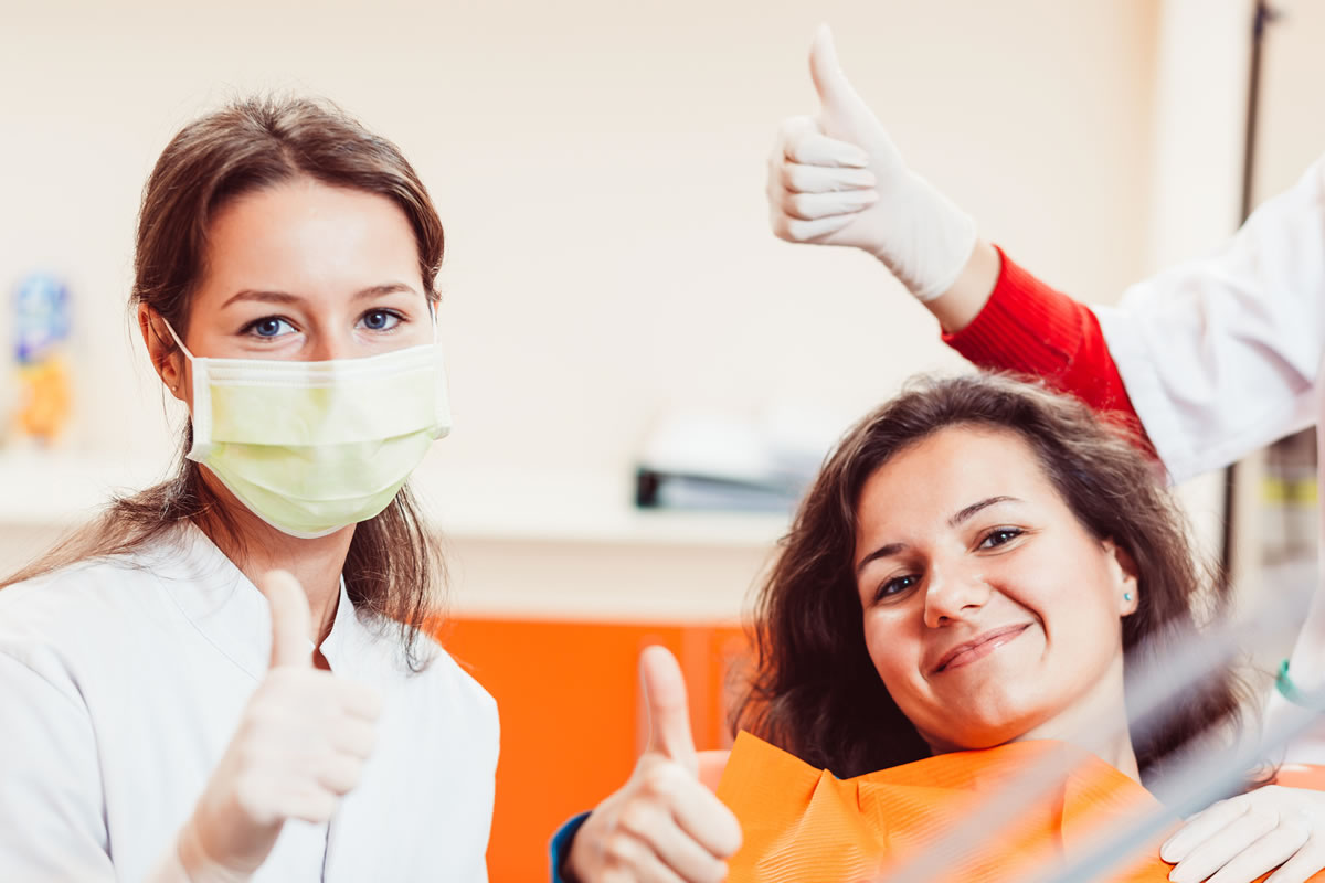 Dental Hygienist and Patient give a thumbs-up after check-up