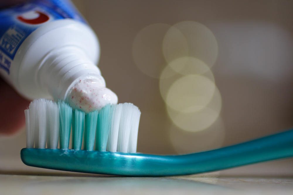 toothpaste being put onto toothbrush