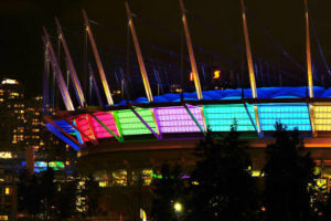 BC place stadium lit up at night with rainbow colours