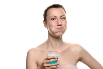 Woman using mouthwash