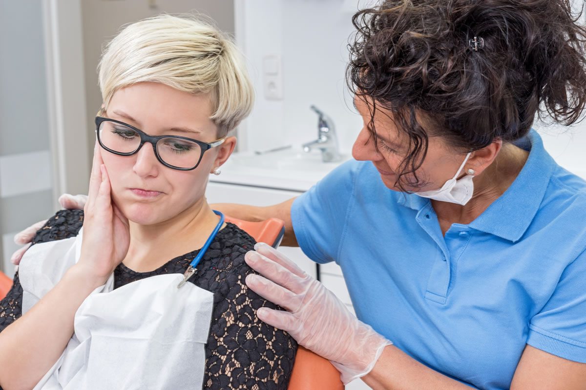 Dentist calming patient in dental chair