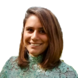 A smiling woman with shoulder-length brown hair wearing a green lace top against a white background.