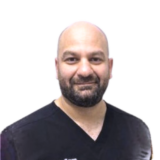 A person with a friendly expression, bald head, and trimmed beard, wearing a black shirt against a white background.