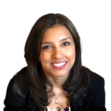 Smiling woman with long dark hair and a necklace, wearing a black top, on a plain white background.