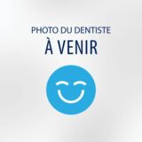 A placeholder image featuring a blue smiley face with the text "PHOTO DU DENTISTE À VENIR," which translates to "Dentist's photo coming soon." The background is light and simple, emphasizing the cheerful expression.