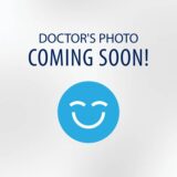 A placeholder image indicating that the doctor's photo is coming soon, featuring a smiling blue emoji on a light background with the text "DOCTOR'S PHOTO COMING SOON!"