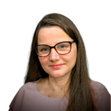A woman with long brown hair and glasses, smiling gently, set against a plain white background.
