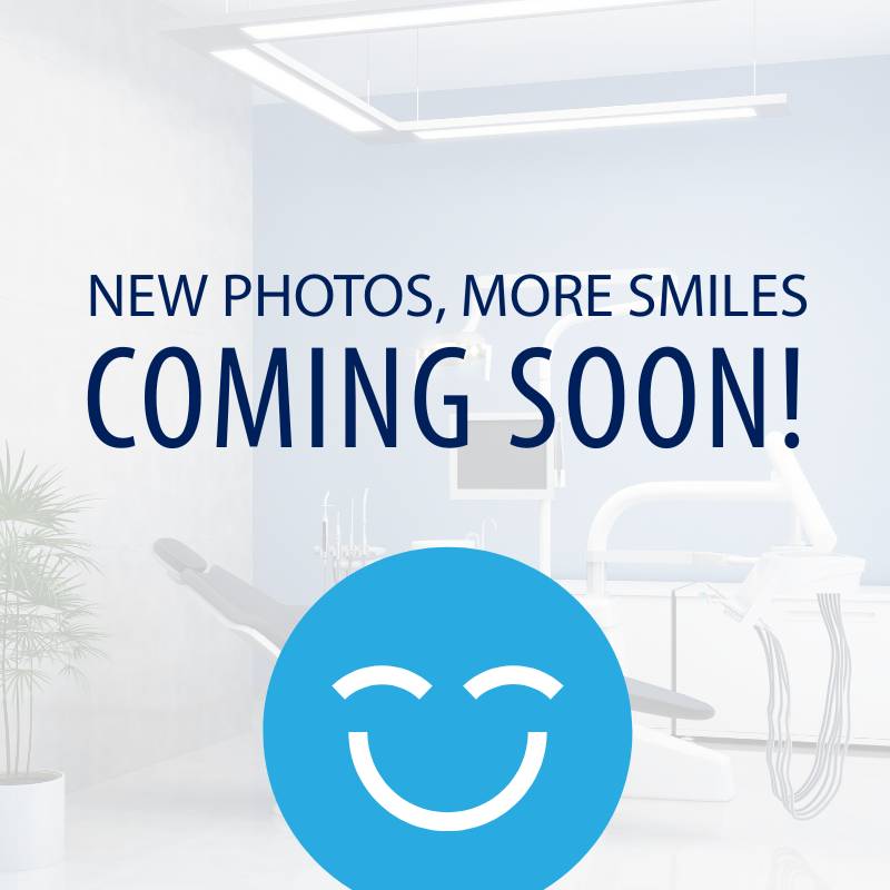 A bright dental office interior featuring a dental chair, with text announcing new photos and smiles coming soon.