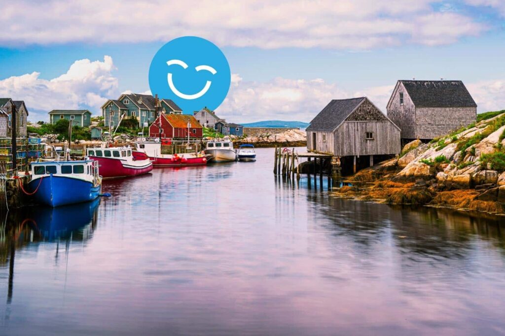 A serene coastal scene featuring colorful fishing boats docked by weathered wooden huts along a calm waterway, under a cloudy sky. A cheerful blue smiley face overlays the image.