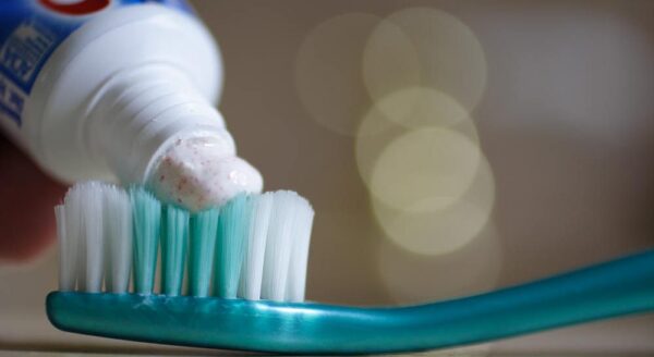 toothpaste being put onto toothbrush