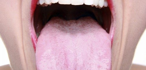 An open mouth showing a pink tongue and white teeth, highlighting oral health.