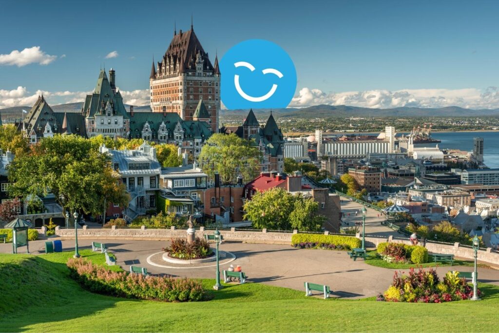A panoramic view of a vibrant cityscape featuring historic buildings, lush greenery, and a waterfront. The scene is bright and inviting, with the sky clear and a cheerful smiley icon overlaying the landscape.