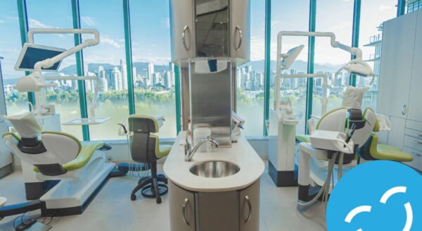 Une clinique dentaire moderne avec de grandes fenêtres offrant une vue sur la ville. L'image présente des fauteuils dentaires, des équipements et un poste de travail central avec un évier, créant un environnement propre et accueillant pour les patients.