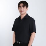 A person with short dark hair wearing a black polo shirt, standing with a light background and a gentle smile.