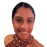 A woman smiling warmly, wearing a polka dot top, against a white background.